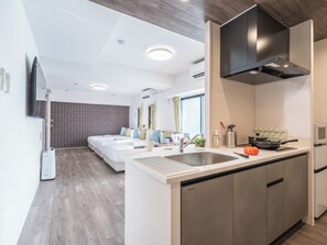 Een moderne hotelkamer met een groot bed, een kitchenette en een badkamer.