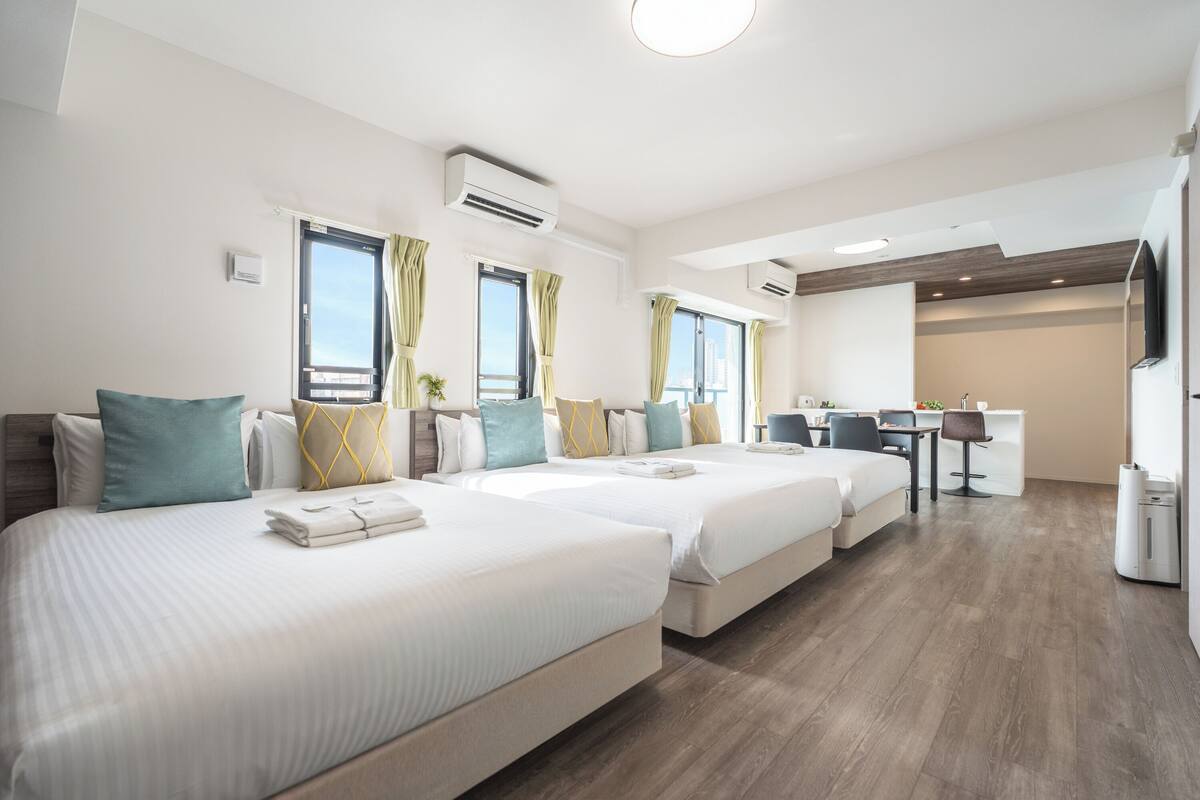 A hotel room with two beds, a desk, and a chair.