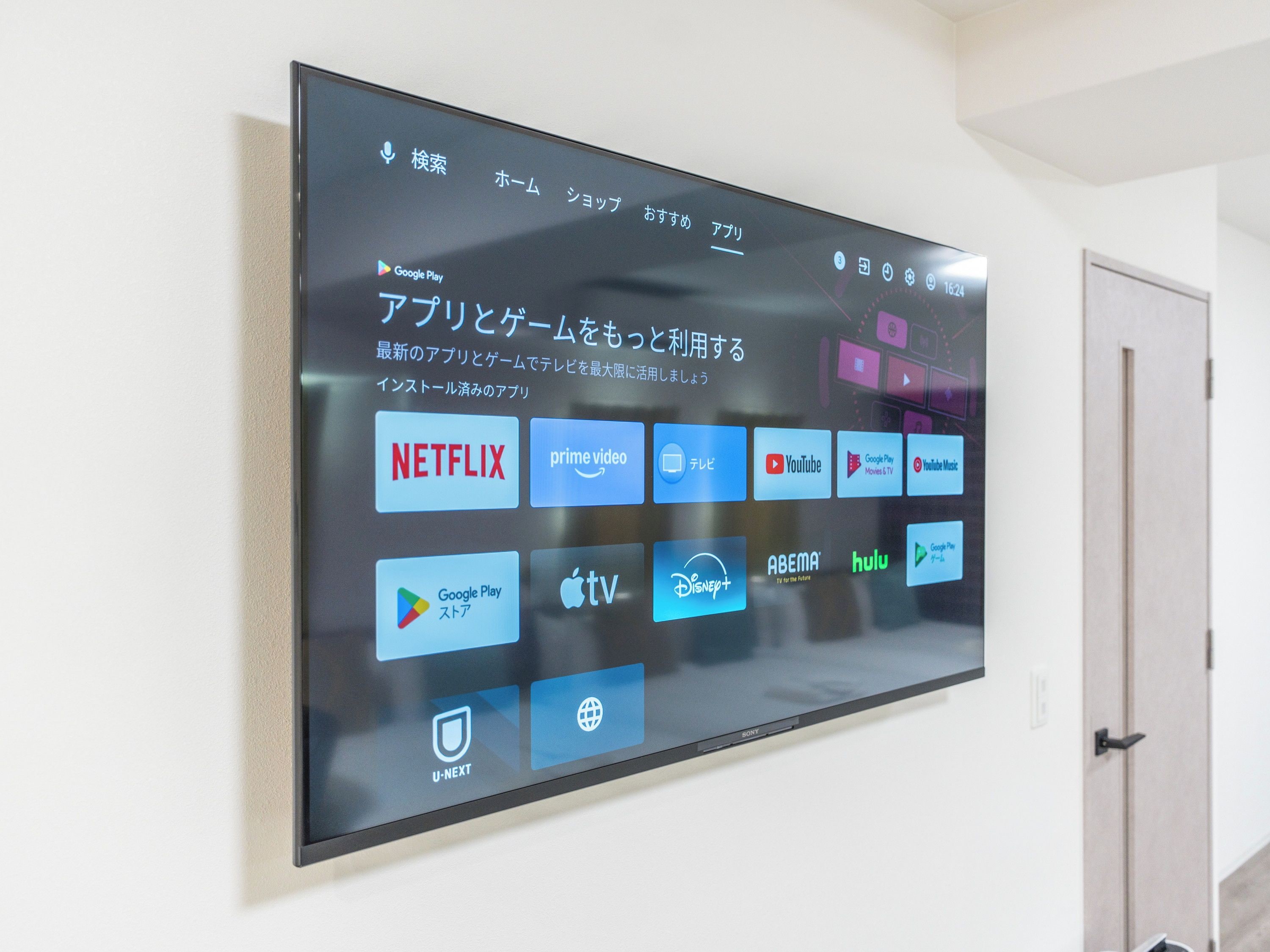 Un televisore montato a parete che mostra icone di diversi servizi di streaming.