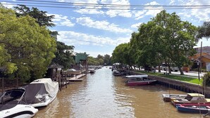 A canal with boats docked on both sides, surrounded by trees and buildings. - Isla Chana Reserva Punta Morán (Tigre)
