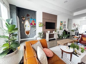 A modern living room with a sofa, coffee table, and potted plants.