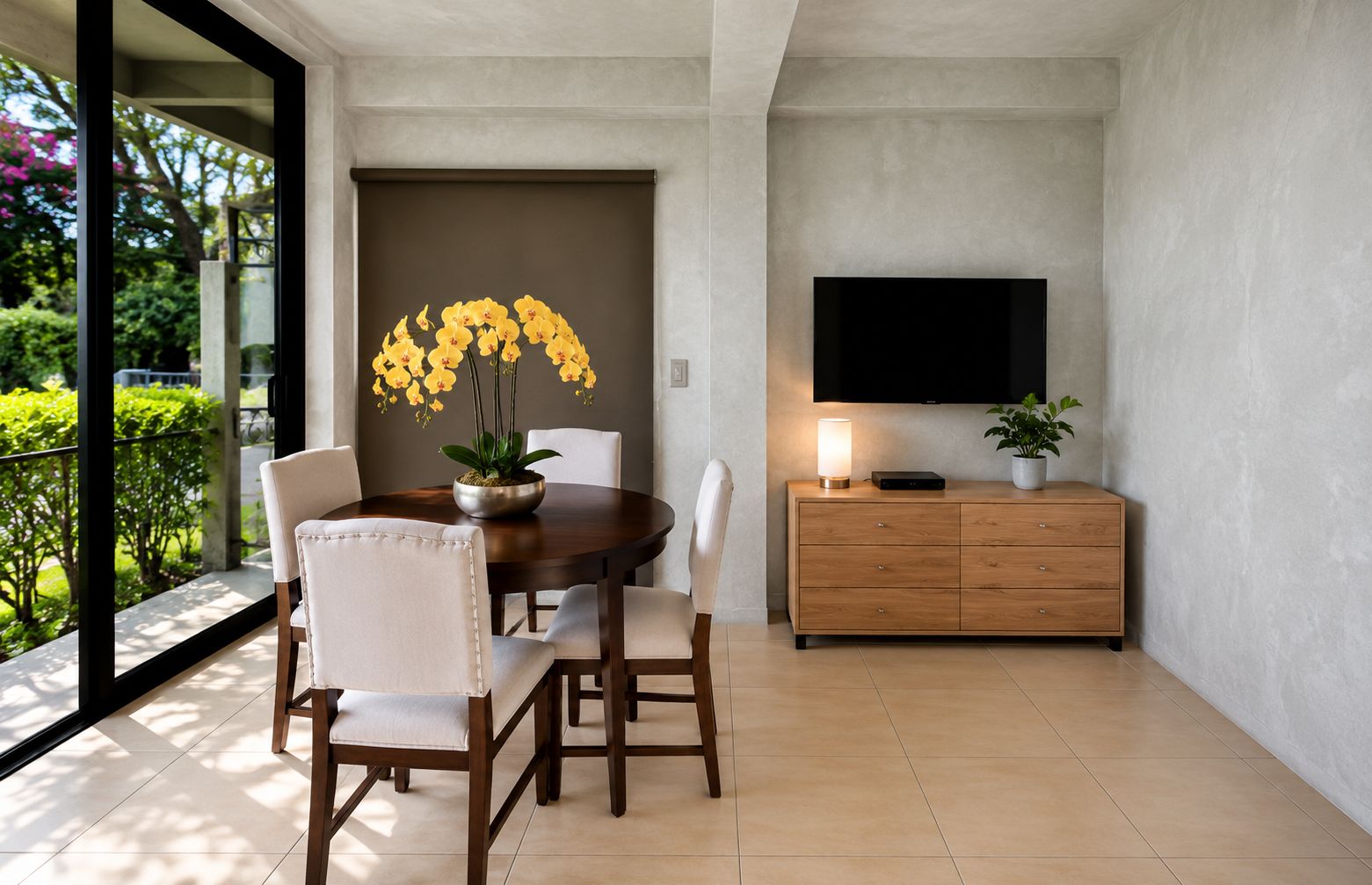 Un comedor moderno con una mesa redonda, sillas, un televisor y un armario.