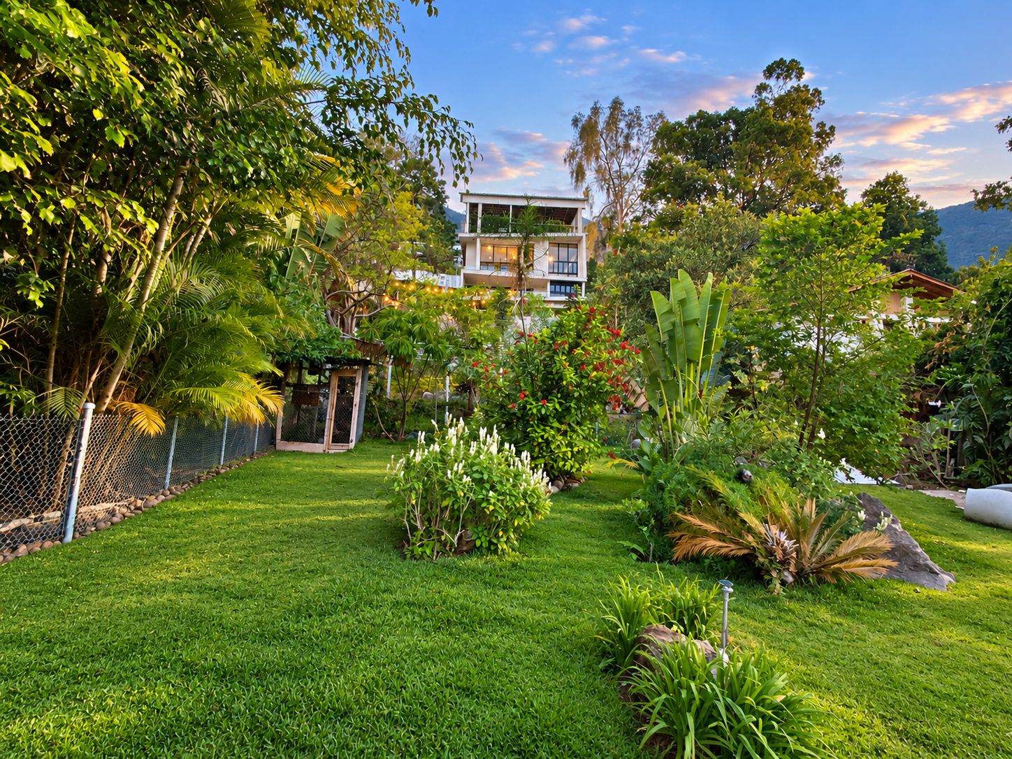 Un jardín bien cuidado con una variedad de plantas y un área cercada.