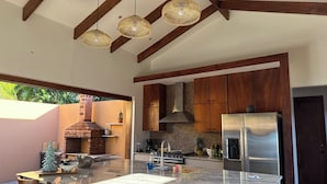 Una cocina moderna con una isla grande, armarios de madera y un horno de ladrillo.