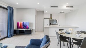 A modern apartment with a living room, dining area, and kitchen.