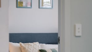A bedroom with a bed, pillows, and a bedside table.