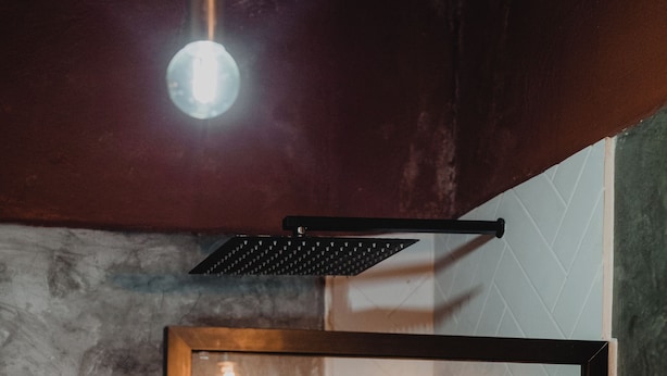 A shower with a glass door, a towel rack, and a light fixture above. - Sayula Home (Sayulita)