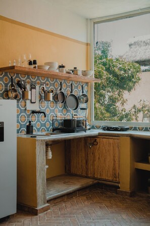 Comfort studio, uitzicht op tuin | Privékeuken | Een kookplaat, kookgerei, borden en bestek