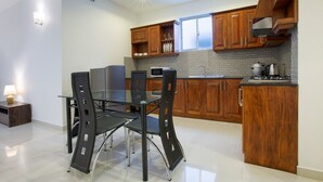 Una cocina moderna con armarios de madera, una mesa de comedor de vidrio y una estufa empotrada.