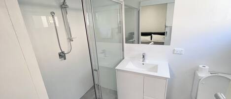 Regadera, secadora de cabello, toallas, papel de baño