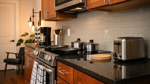 Une cuisine avec des meubles en bois, une cuisinière en acier inoxydable, un four à micro-ondes et un grille-pain.