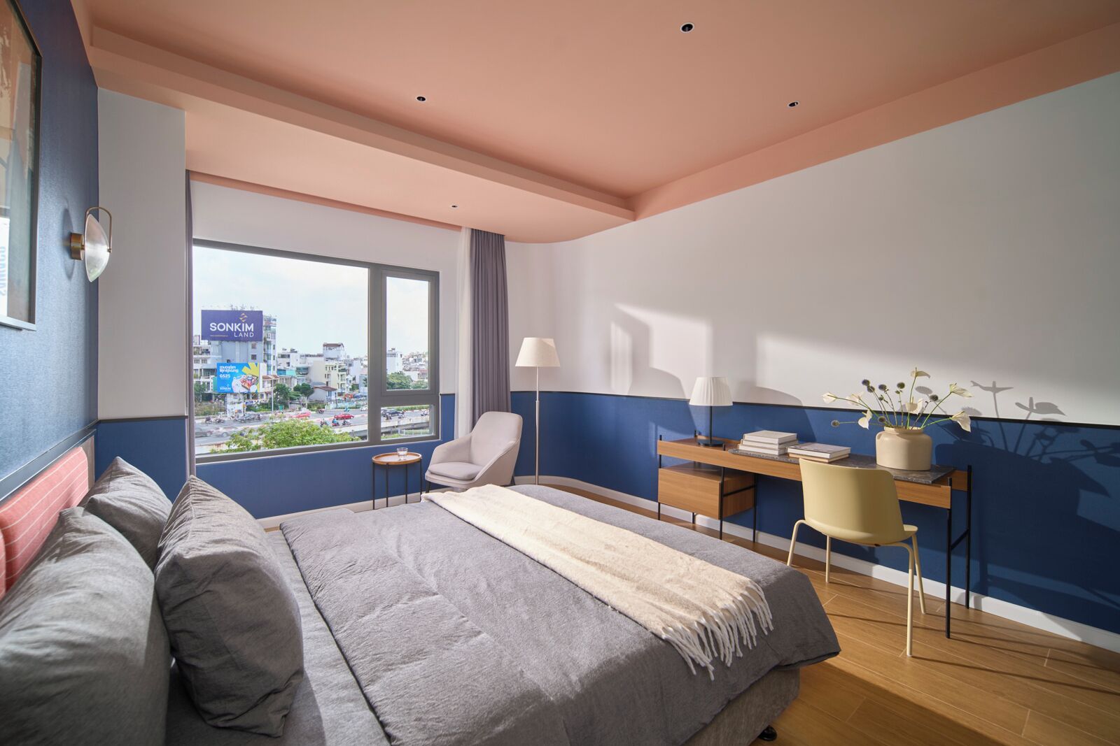 Une chambre d’hôtel moderne, dotée d’un grand lit, d’un bureau et offrant une vue sur la ville.
