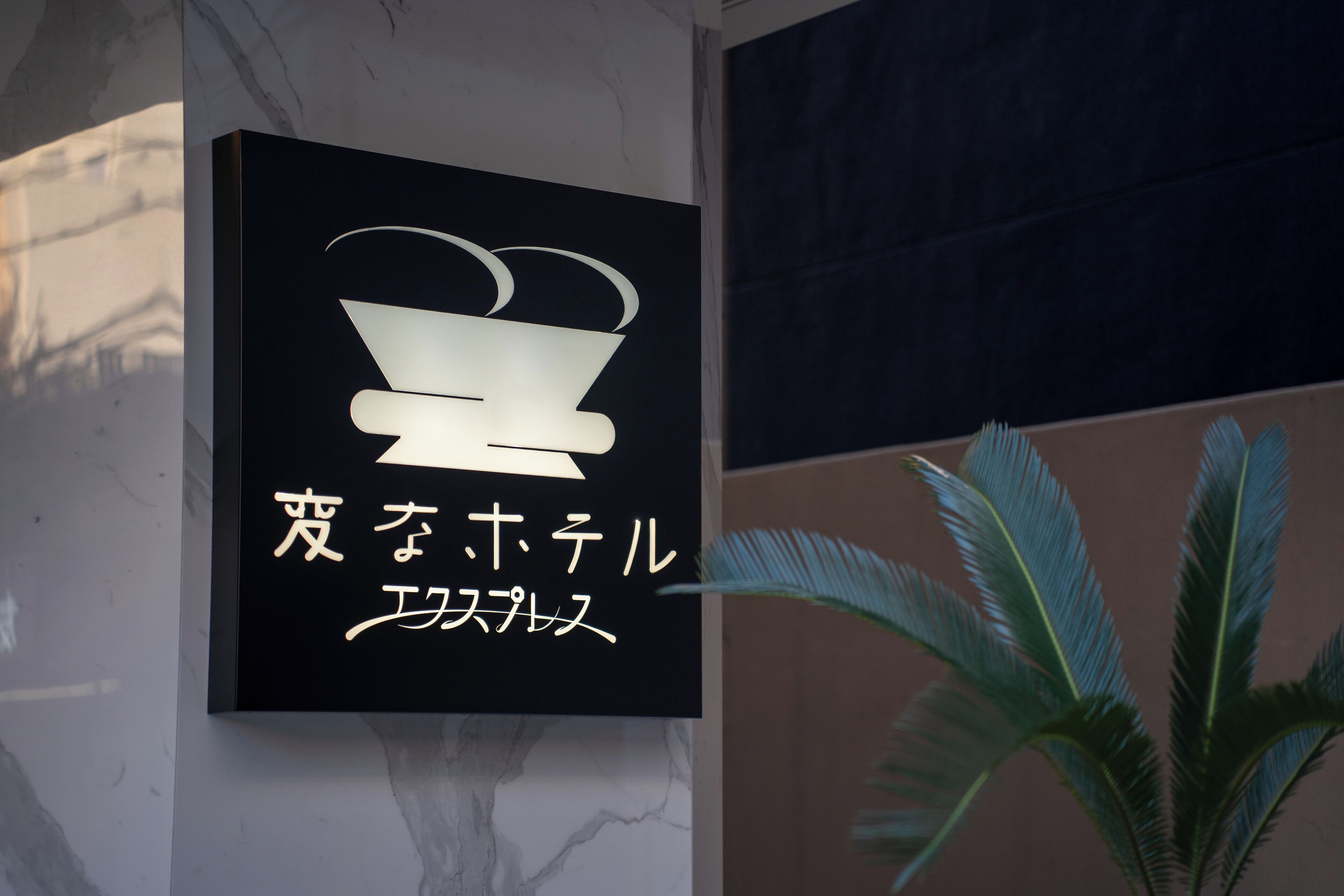 A sign with a logo and Japanese text, indicating a restaurant or dining area.