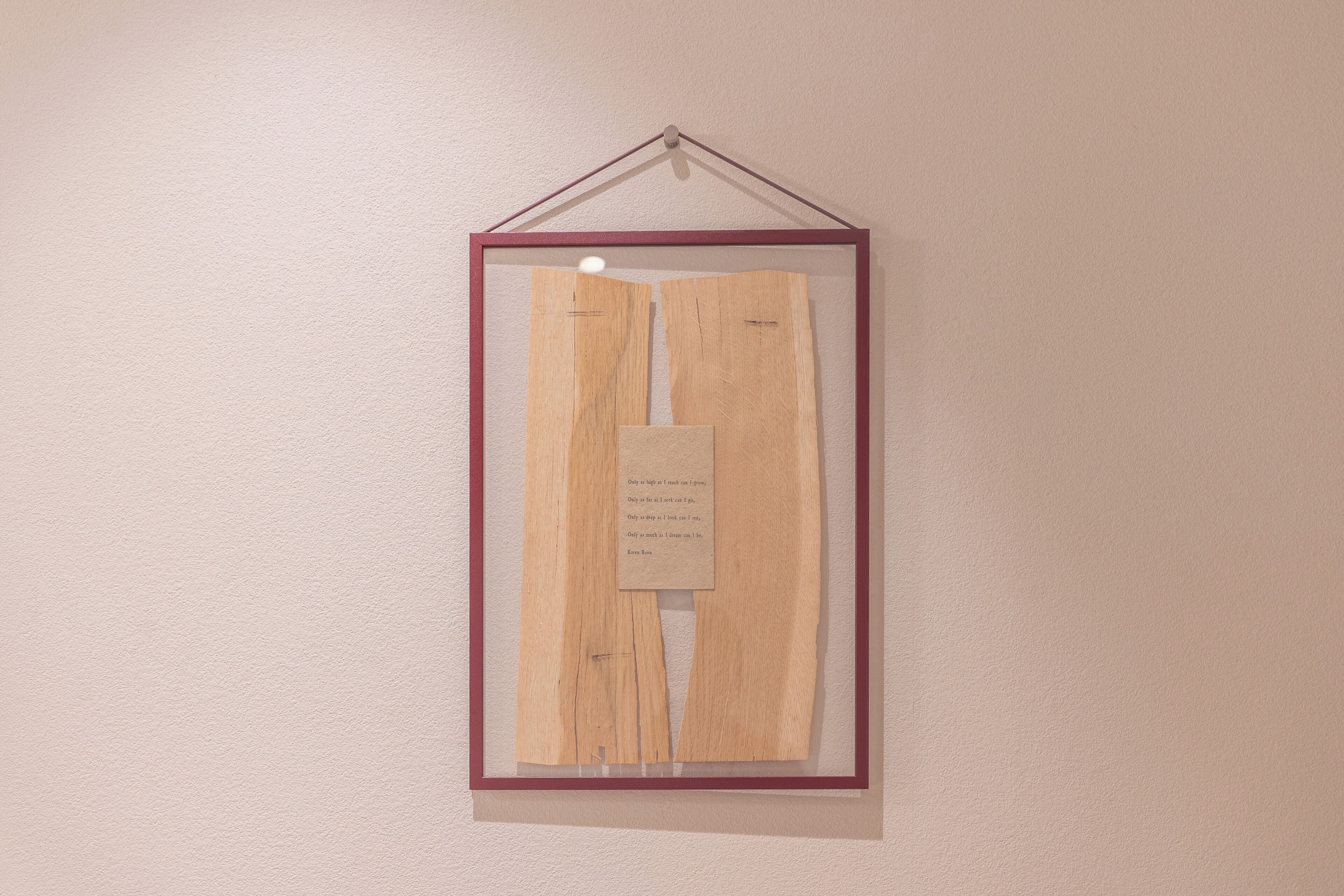 A framed piece of artwork with text on a wall.