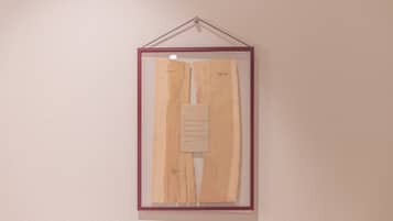 A framed piece of artwork with text on a wall.