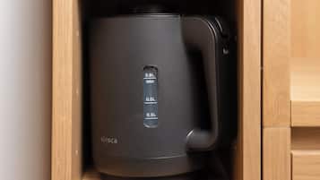 Una cafetera negra con pantalla digital que muestra los niveles de agua en mililitros.