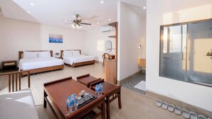 A hotel room with two beds, a dining table with water bottles, a ceiling fan, and a large window. - Sentina Phu Quoc Hotel (Phu Quoc)