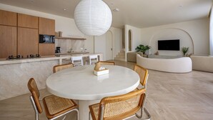Una cocina moderna con armarios de madera, una mesa redonda para comer y una lámpara colgante grande.