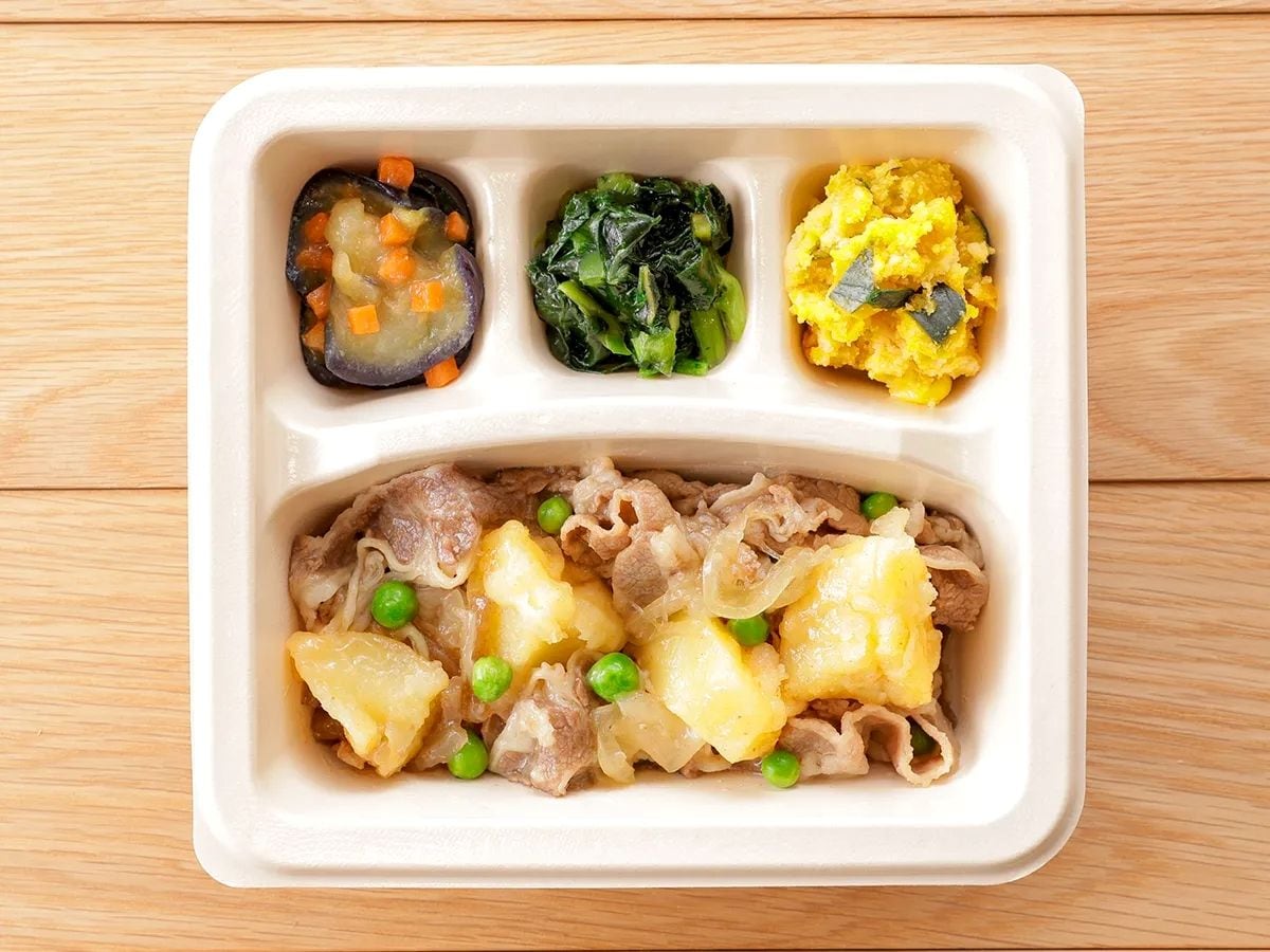 A meal in a compartmentalized container with sections for different dishes.