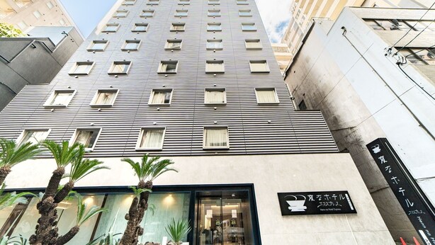 Un moderno edificio de hotel con fachada de vidrio, múltiples ventanales y una señal que indica que es el Henn na Hotel Express.