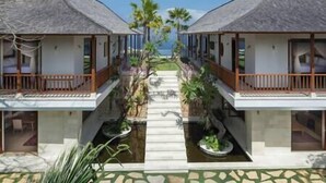Ein Resort mit zwei identischen Gebäuden, jedes mit einem Balkon, einem kleinen Pool und Blick auf den Ozean.