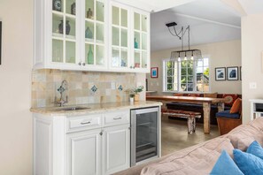 A kitchen with white cabinets, a tiled backsplash, and a built-in refrigerator. - Gorgeous Pleasure Point Home - Sleeps 10! (Santa Cruz)