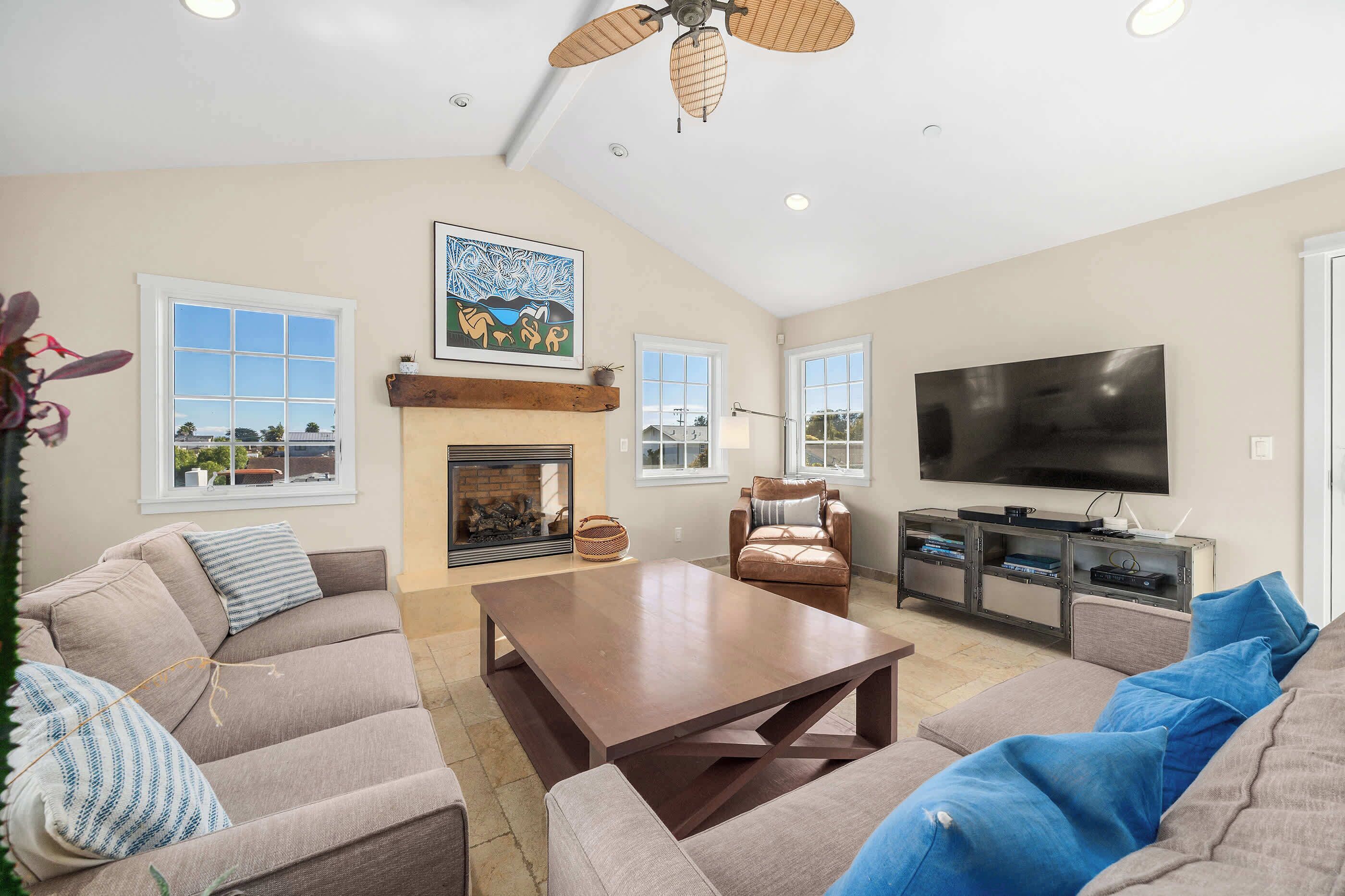 A spacious living room with a fireplace, a large TV, and comfortable seating.