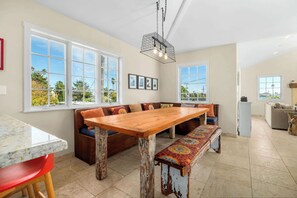 Una cocina amplia con una gran mesa de madera, banco incorporado y una lámpara colgante.