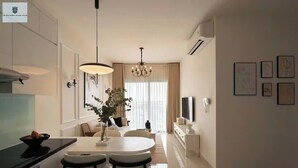 Una cocina moderna con comedor, que incluye una lámpara de araña, un televisor de pantalla plana y obras de arte en las paredes.