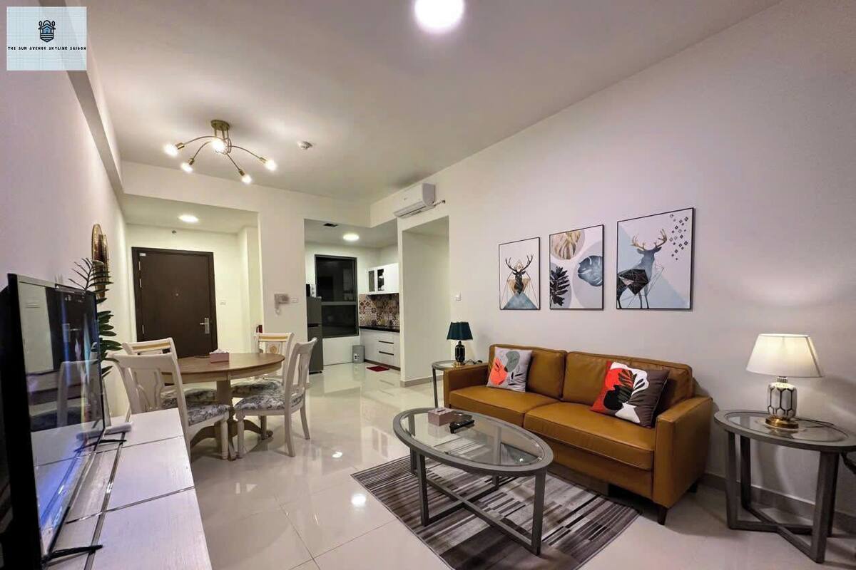 A modern living room with a sofa, coffee table, and a dining area with chairs.