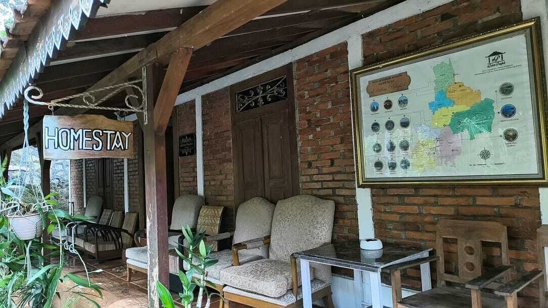 Un espacio al aire libre acogedor con un letrero que dice 'HOMESTAY', un mapa y muebles rústicos.