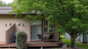 A house with a covered porch, a sliding glass door, and outdoor seating.