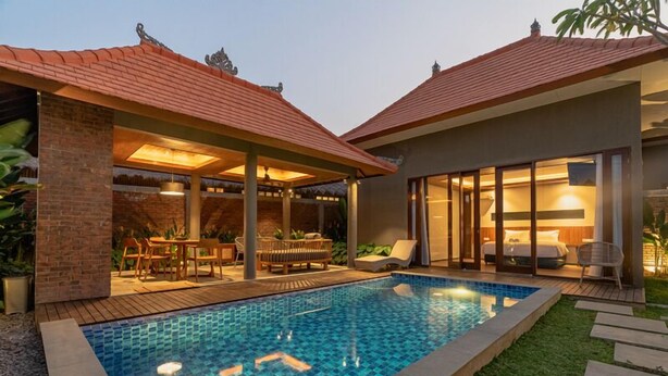 A modern house with a swimming pool, covered patio, and a separate bedroom with a large window.