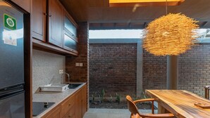 A kitchen with wooden cabinets, a granite countertop, and a hanging light fixture.
