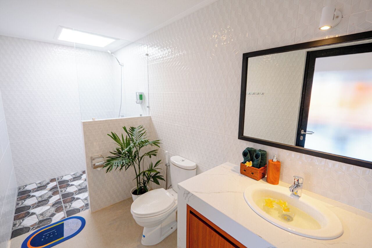 A bathroom with a toilet, sink, and a mirror.