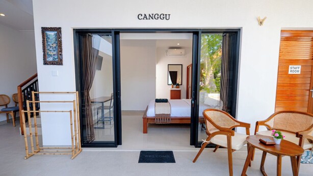 A hotel room with a bed, a desk, and two chairs. There is a sign that says "STAFF ROOM" on the door. - Crystal Flow Guest House & Apartment Canggu (Canggu)