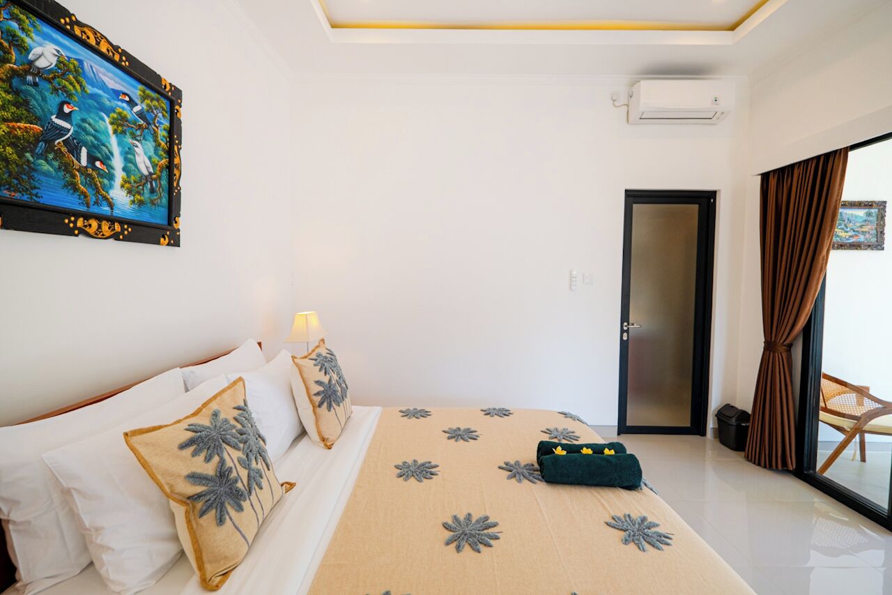 Une chambre d’hôtel avec un lit, un tableau, une porte et une vue par la fenêtre.