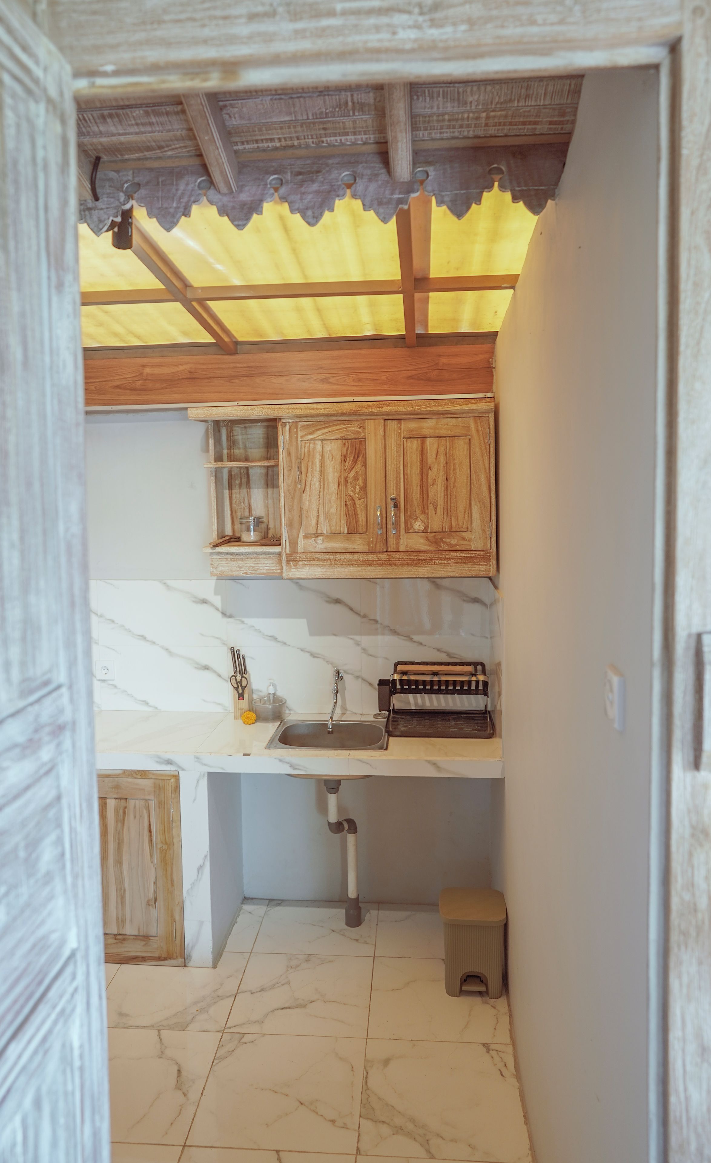 Une cuisine avec des meubles en bois, un plan de travail en marbre et un évier.