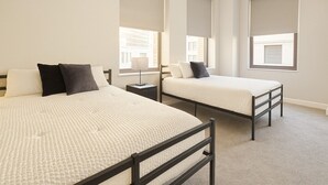 A hotel room with two beds, a nightstand, and large windows with blinds. - Downtown Suite - Spacious! RnRHoF, Casino, Stadium (Cleveland)