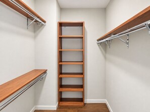 Un dressing avec des étagères en bois et des supports métalliques.
