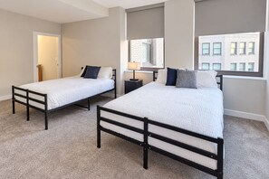 A hotel room with two beds, a window, and a door. - Downtown Suite - Spacious! RnRHoF, Casino, Stadium (Cleveland)