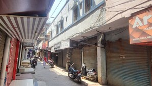 Une rue étroite, bordée de boutiques fermées et de motos garées.