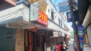 Un hôtel appelé « Victoria Grand », avec une enseigne bien visible et un panneau indiquant « Er. Manish Gupta » sur le côté droit.