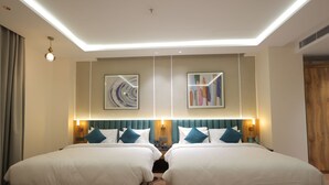 Une chambre d’hôtel avec deux lits, un luminaire au plafond et deux lampes fixées au mur.