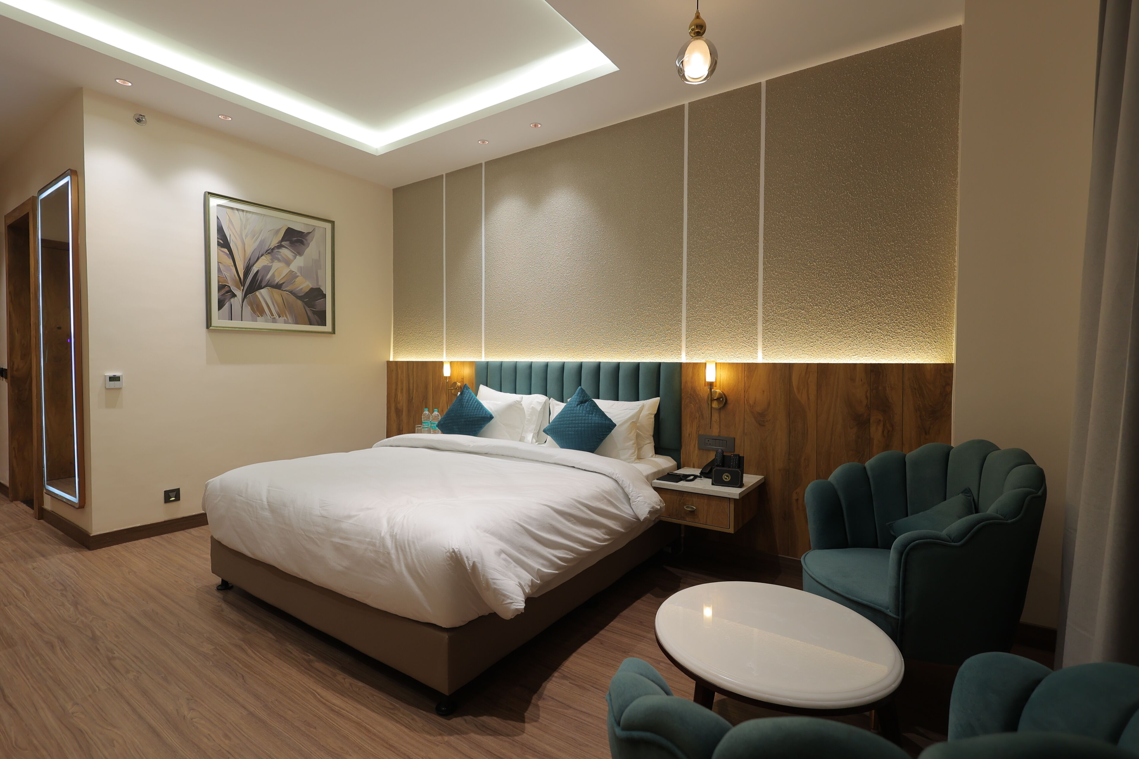 Une chambre d’hôtel moderne avec un grand lit, une table de chevet, une chaise et une petite table.
