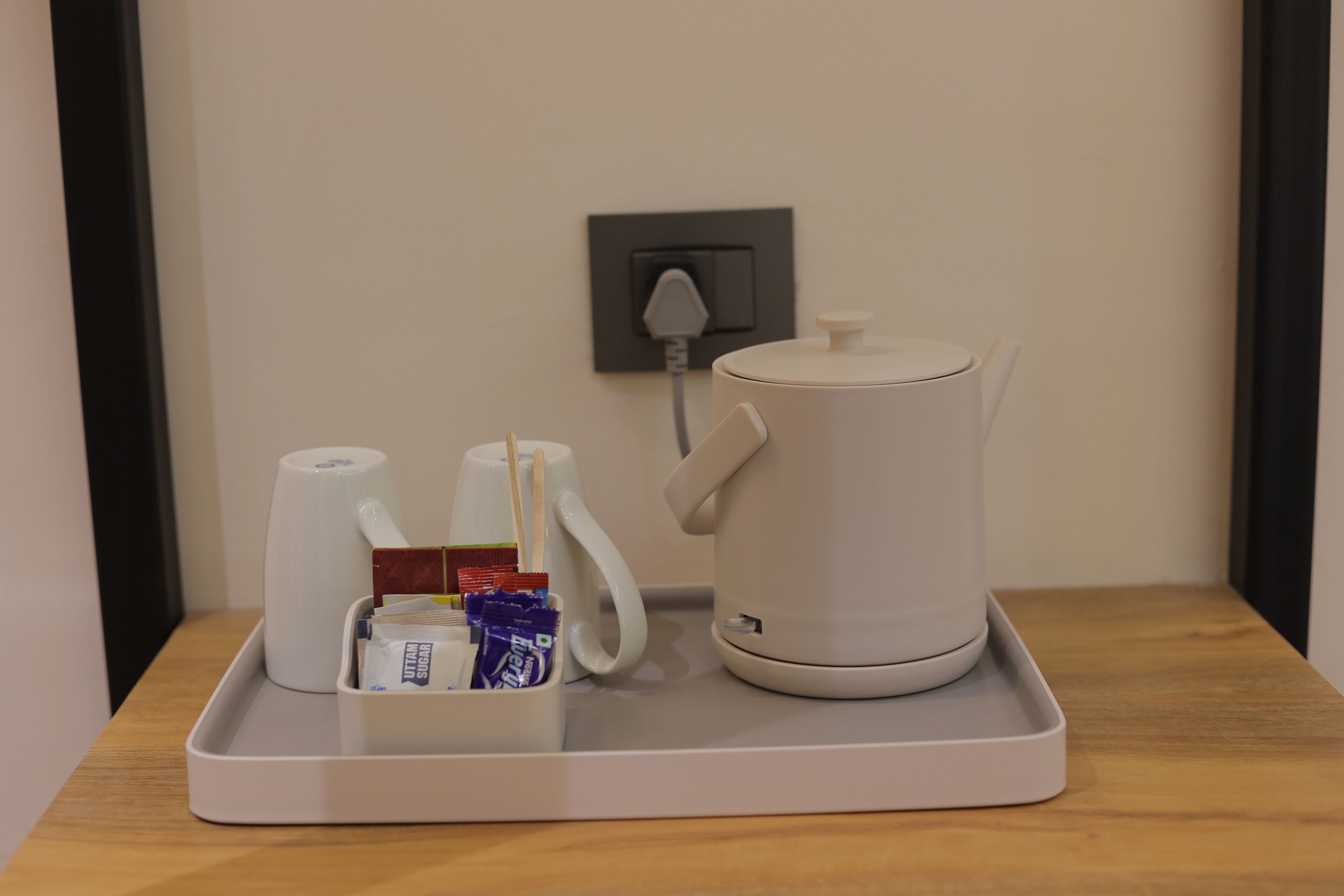 A tray with a coffee maker, a cup, and a box of tissues.