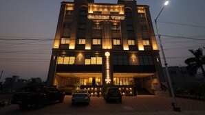 Un hôtel appelé « Garden View », doté d’une entrée imposante, de plusieurs étages et d’une façade bien éclairée.
