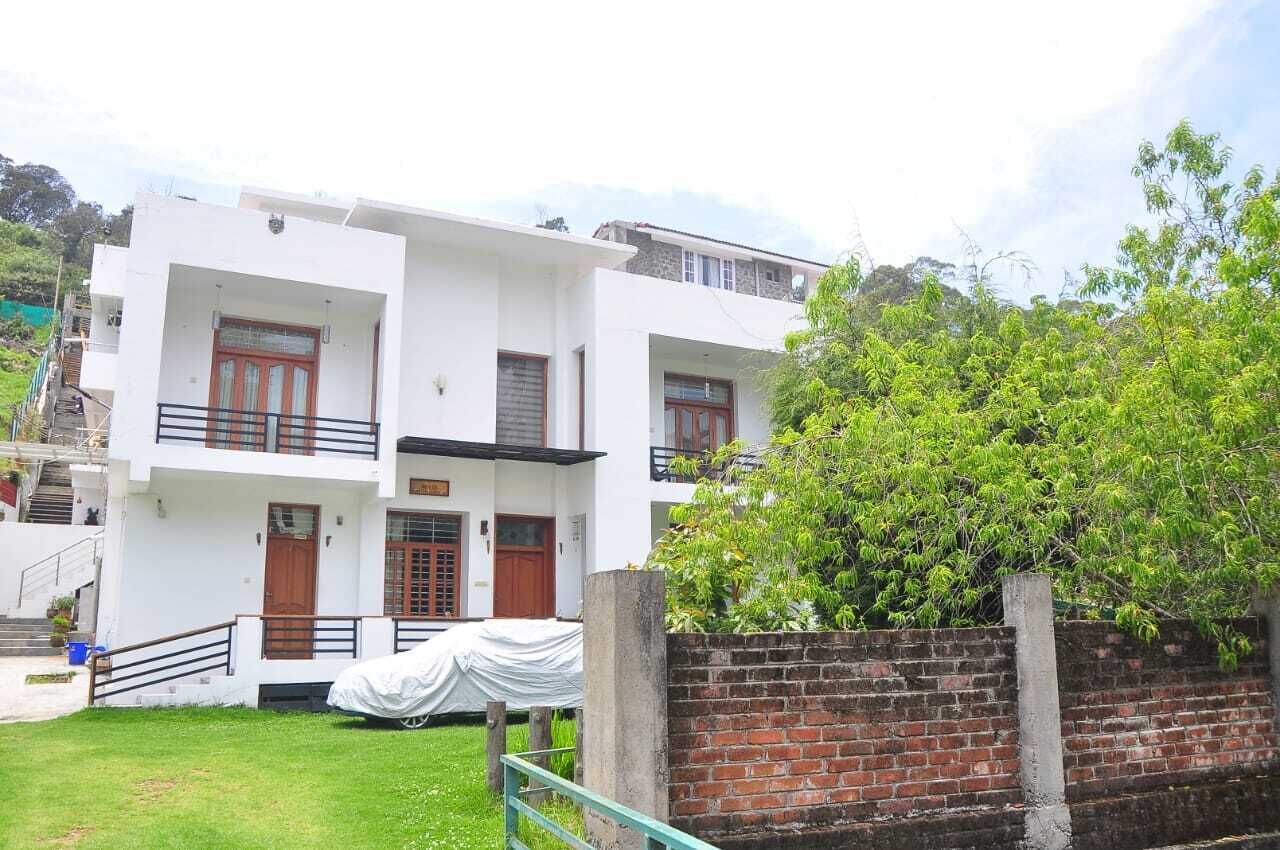 A two-story building with a flat roof and a brick wall.