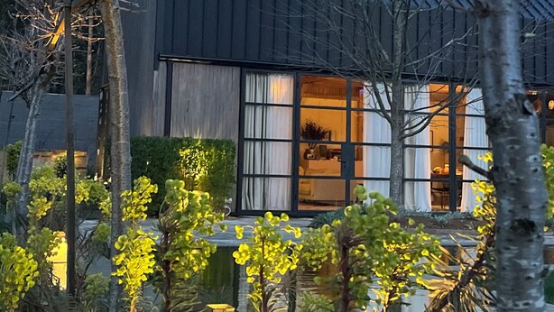 A modern house with a dark roof, large windows, and a well-lit interior. - The Barn at Stonewalls - Farm stay in 25 acres In Daylesford (musk)