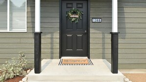 A front door with a 'welcome' sign, a mailbox, and a house number 1388. - Cowboy Condo in Charming Shelby (Shelby)